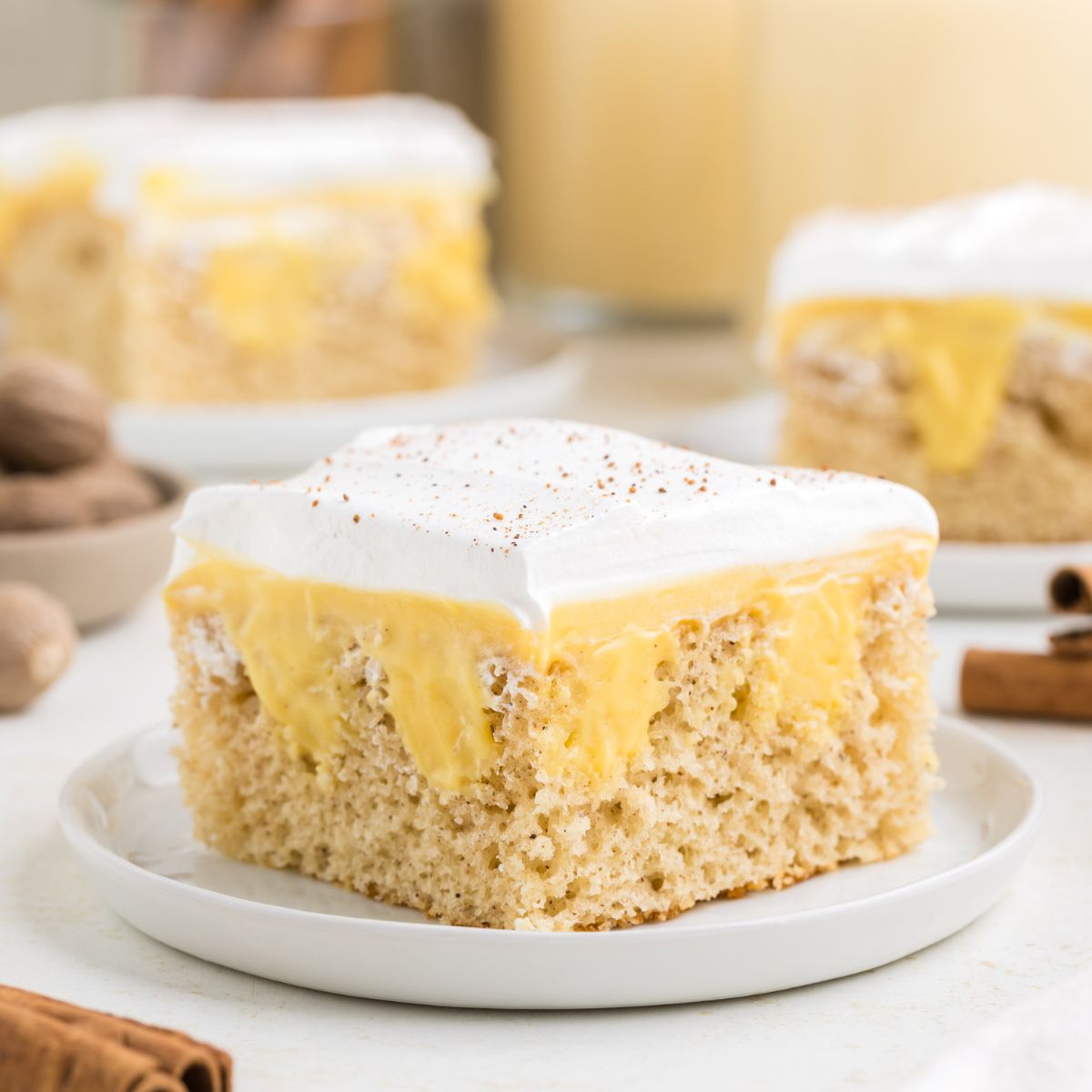 Slice of eggnog poke cake on a plate.