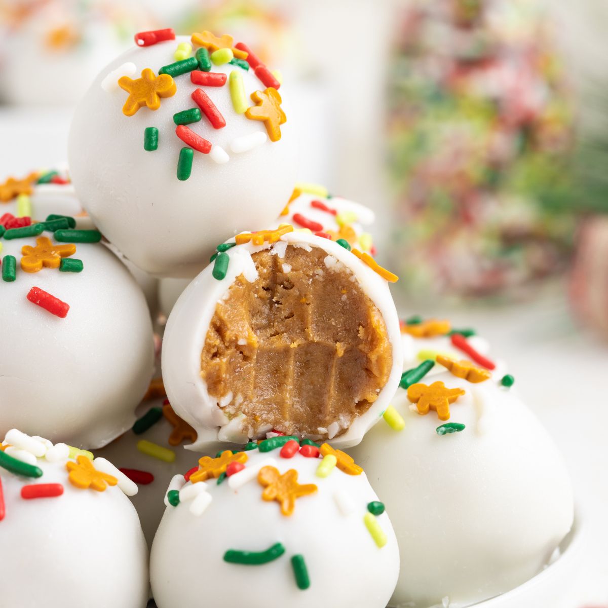 Gingerbread truffles stacked on a plate with a bite missing from one truffle.