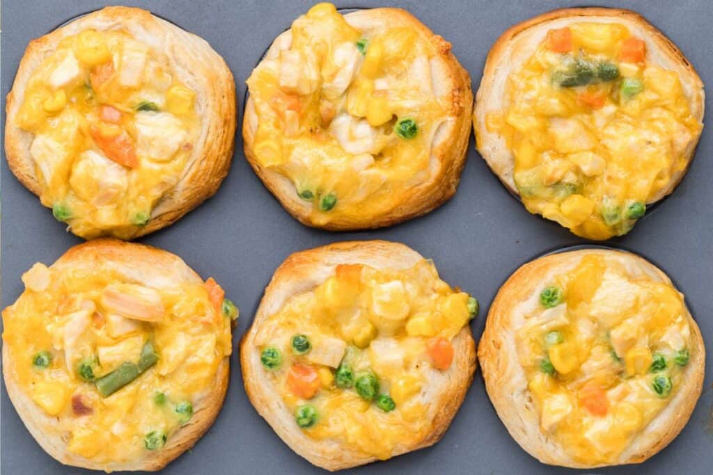 Six muffin pan mini chicken pot pies with golden biscuit crust.