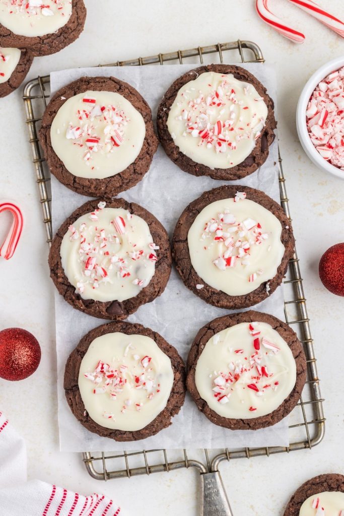 Six peppermint bark brownie cookies on a cooking rack. 