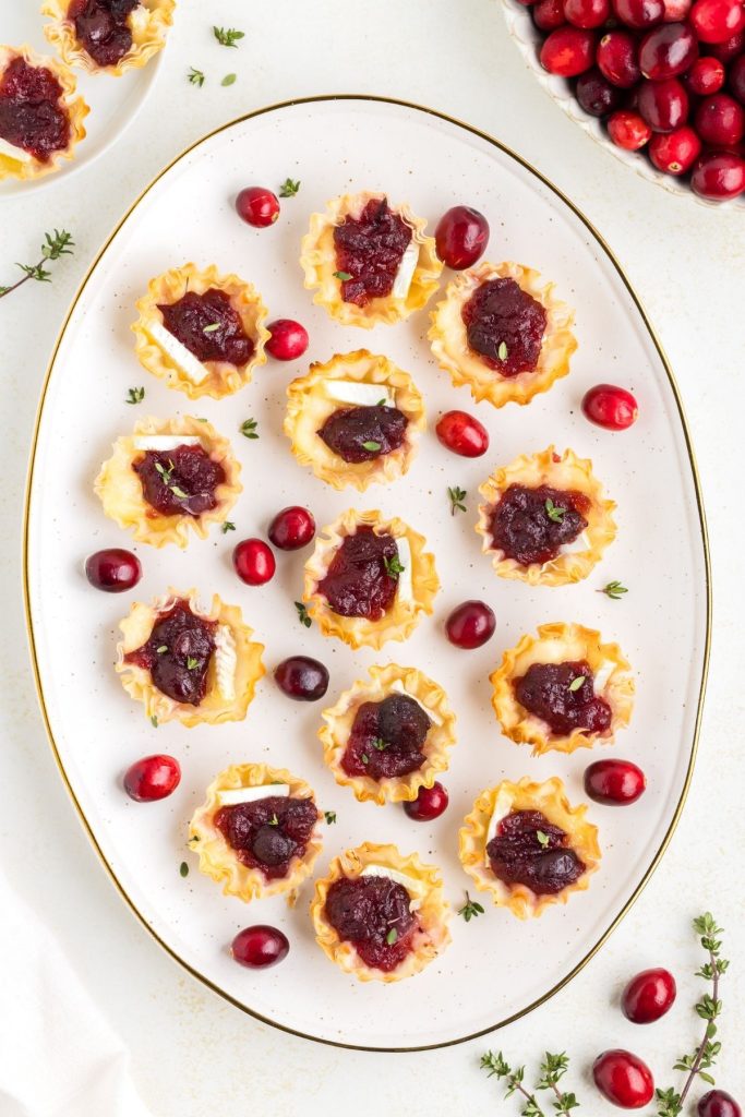 Platter of Brie and cranberry phyllo cups on the counter. 