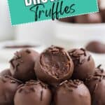 Plate of brownie truffles, some with chocolate sprinkles; one bitten open. Sign above reads BROWNIE Truffles.