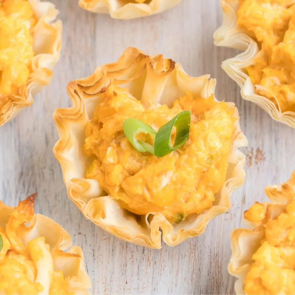 Buffalo Chicken Phyllo Cups arranged on a wooden board.