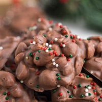 Pile of easy Crockpot Candy Clusters topped with festive sprinkles.
