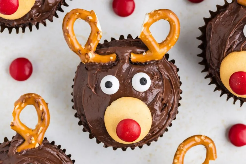 Easy reindeer cupcakes arranged on the counter and surrounded by red M&Ms.