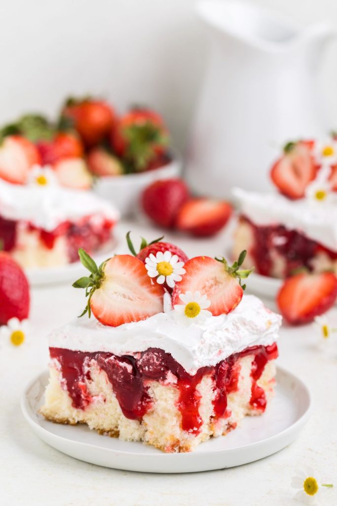 Three slices of Strawberry Shortcake Poke Cake displayed on the counter
