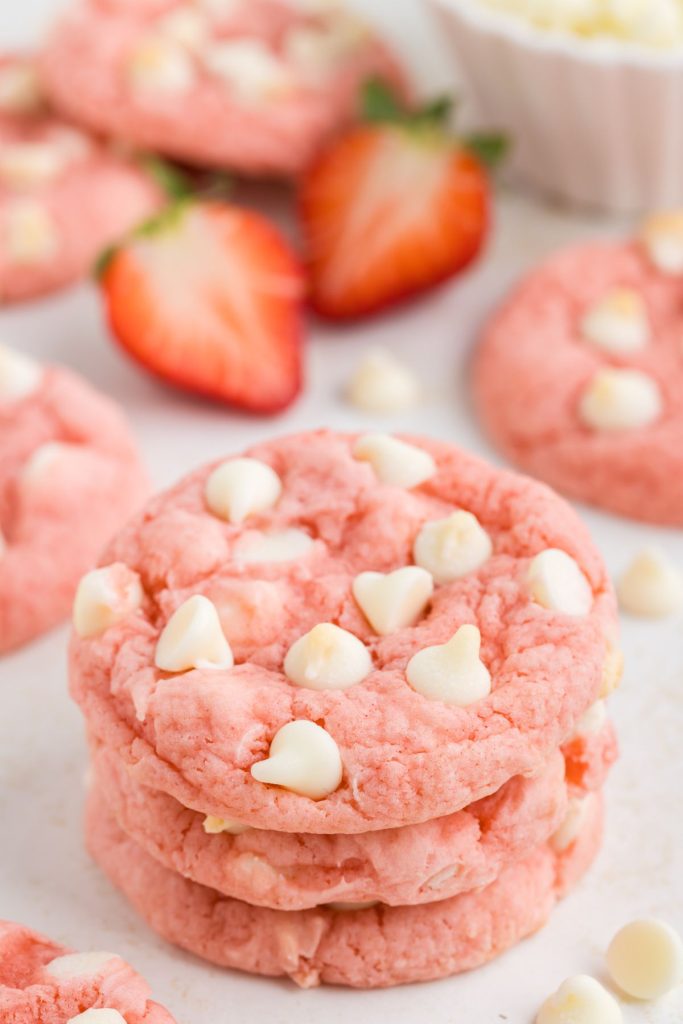 Stack of three strawberry cake mix cookies with white chocolate chips. 