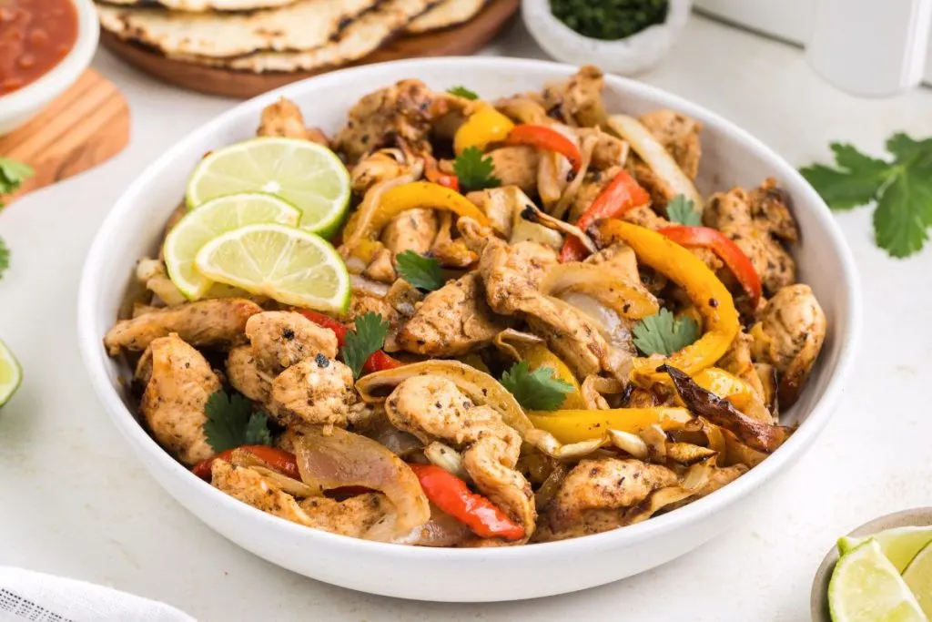 Air fryer chicken fajitas in a bowl on the counter.