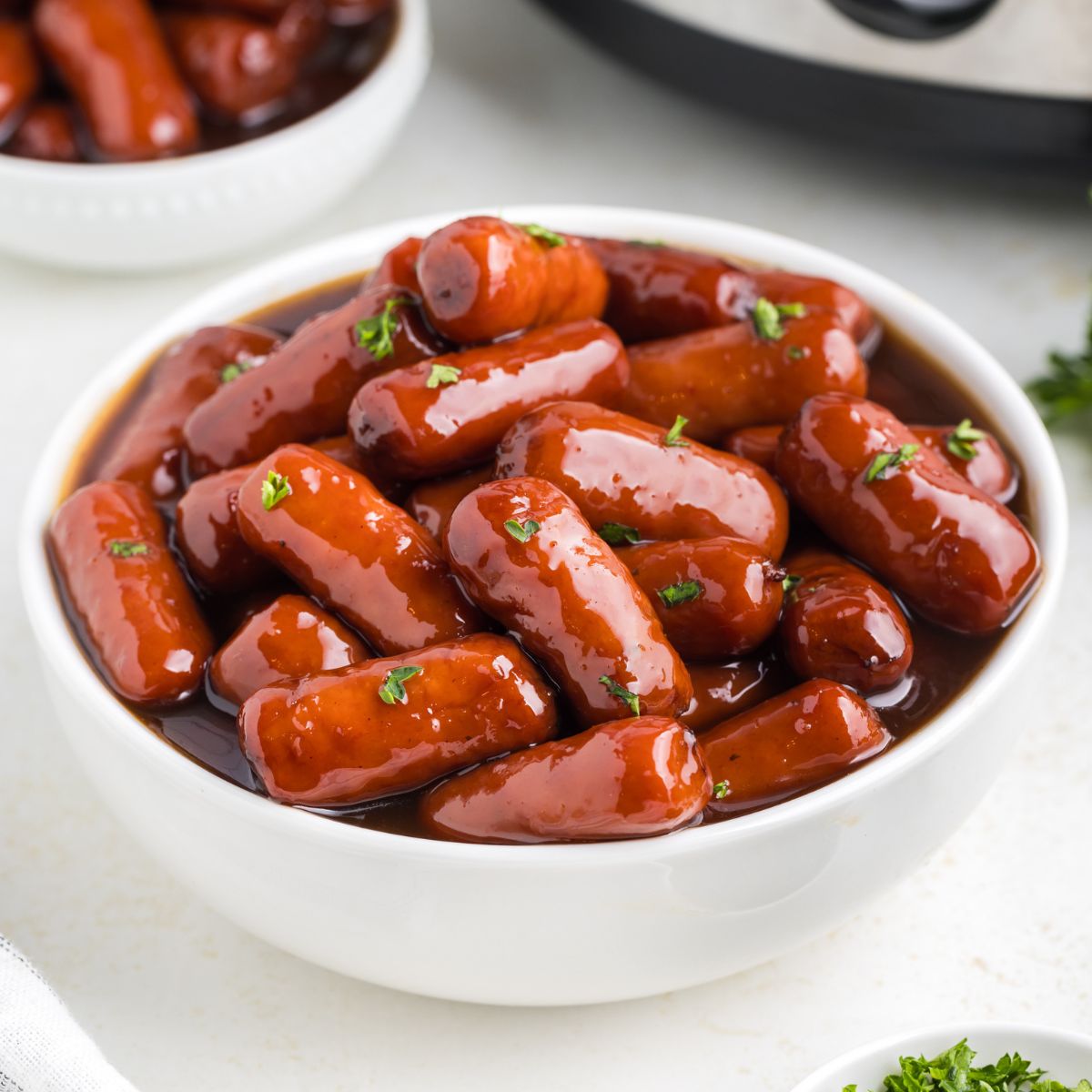 Bowl of little smokies cooked with grape jelly on the counter.