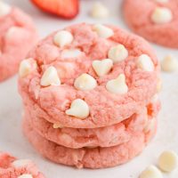 Stack of three strawberry cake mix cookies with white chocolate chips.