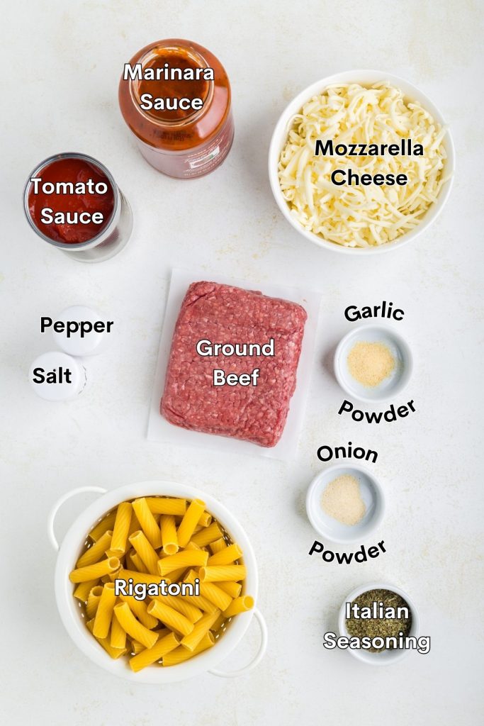 Ingredients for baked beef rigatoni in bowls: ground beef, pasta, mozzarella, tomato sauce, herbs, and spices.