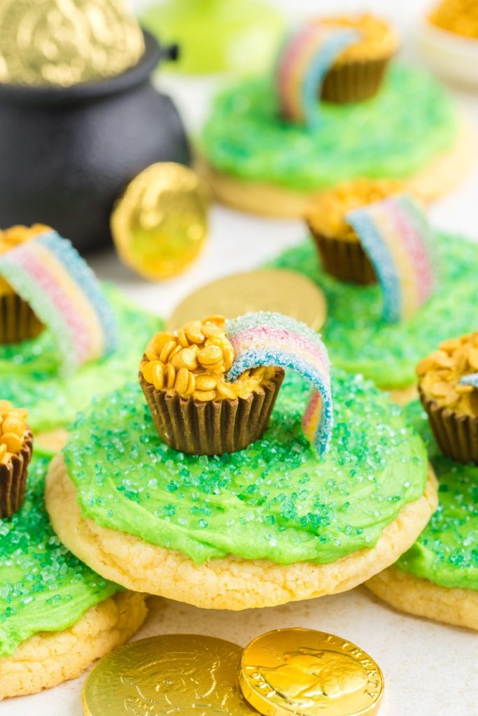 Pot of gold cookies piled on the counter surrounded by gold coins. 
