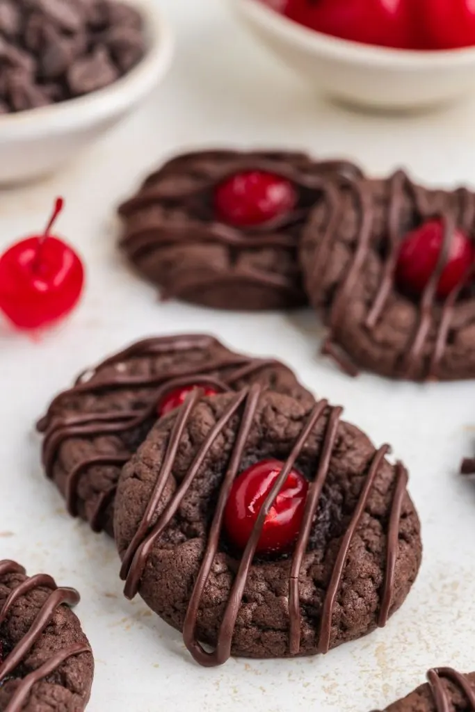 Chocolate cake mix cookies with cherries on the counter. 