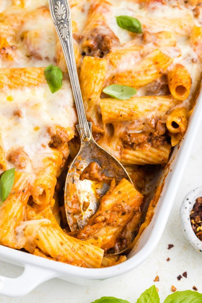 Baked rigatoni dish with layers of meat and cheese, served golden brown and bubbling with deliciousness.