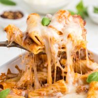 Cheesy baked rigatoni with a spoon, a delicious and comforting dish perfect for pasta lovers.