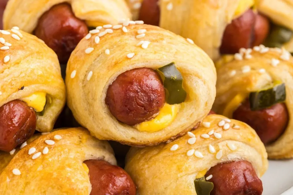 Pile of cheeseburger pigs in a blanket.