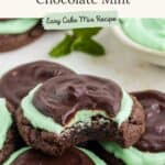 Grasshopper Cake Mix Cookies topped with green mint frosting and chocolate, one bitten to show layered interior.
