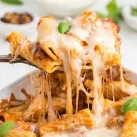 Cheesy baked rigatoni with a spoon, a delicious and comforting dish perfect for pasta lovers.