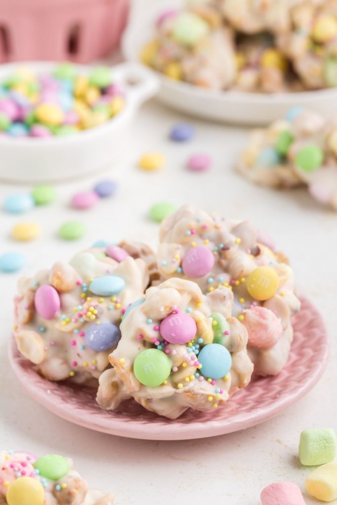 A plate filled with Crockpot Easter Candy topped with colorful M&Ms and sprinkles.