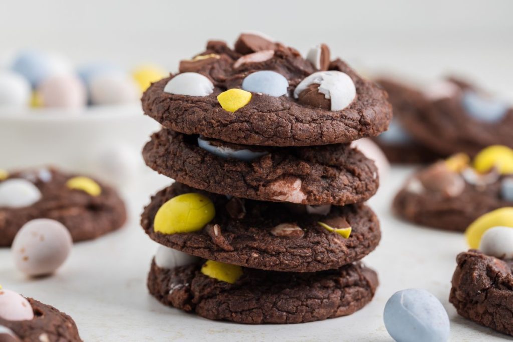 Pile of brownie cookies with colorful Easter eggs on top. A delightful treat for the Easter season.