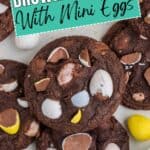 Brownie cookies with mini egg candy pieces on top, arranged on a surface. Label: Mini Egg Brownie Cookies.