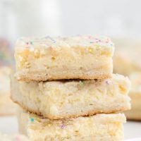 Stack of three sugar cookie cheesecake bars.