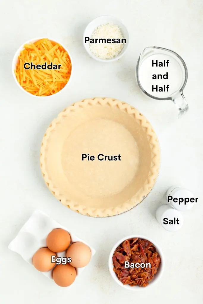 Ingredients such as eggs, bacon, cheddar cheese and pie crust displayed on the counter. 