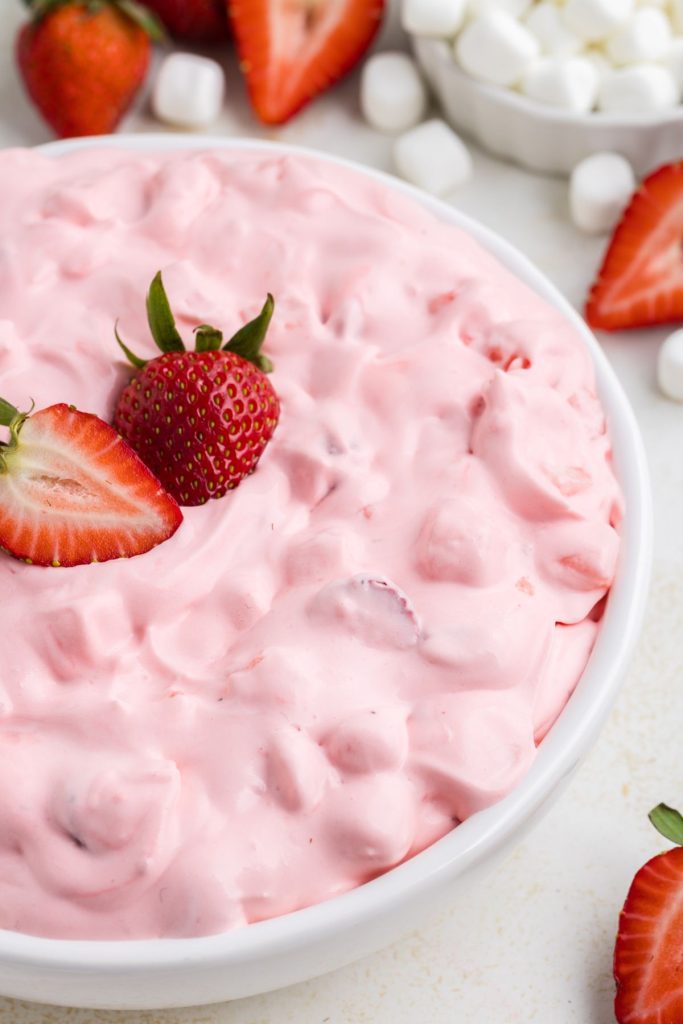 Creamy strawberry fluff salad with fresh cut strawberries. 