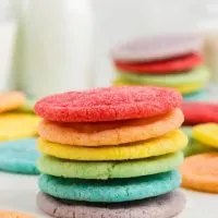 A stack of rainbow colored jello cookies on the counter.