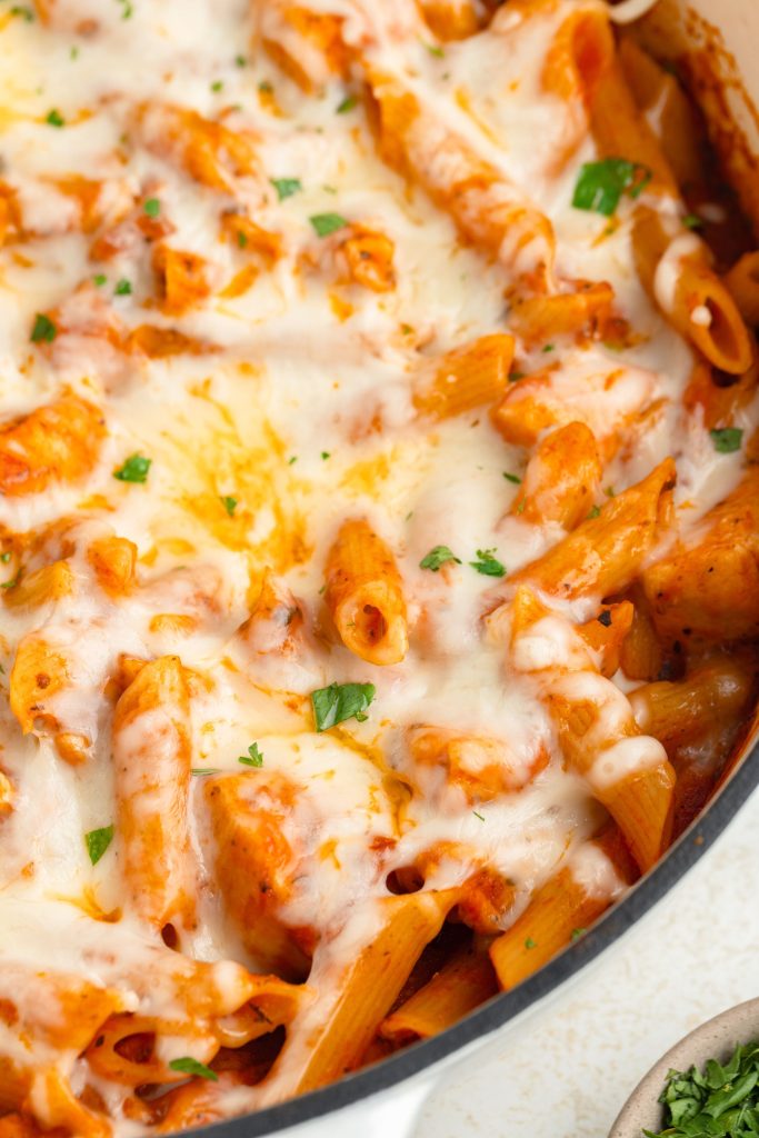 Chicken parmesan pasta covered in mozzarella cheese in a pan.