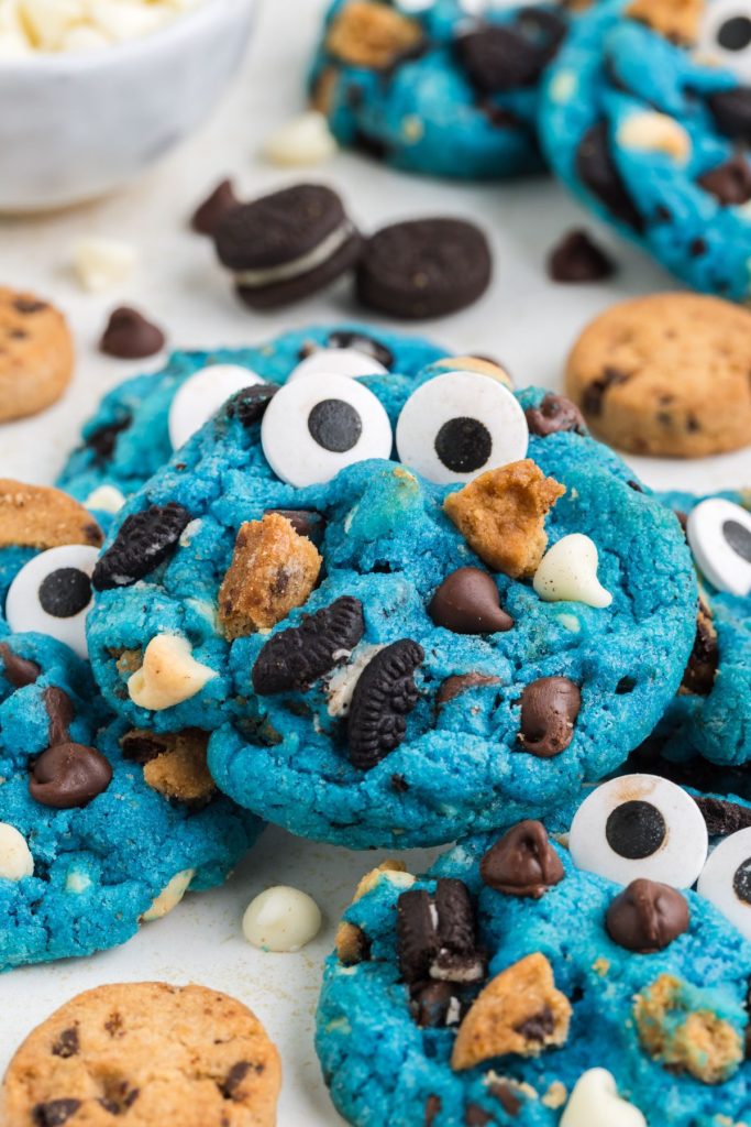Pile of blue Cookie Monster cookies with mini Oreos and Chips Ahoy cookies.