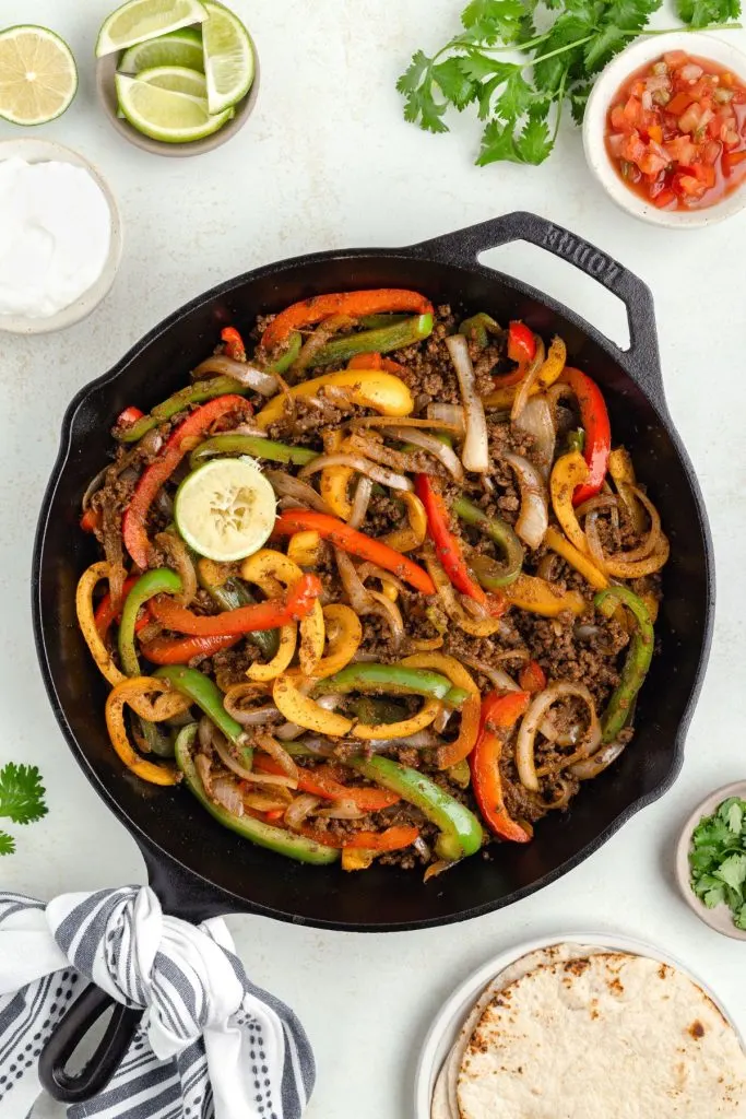 Fajitas with ground beef in a cast iron skillet.