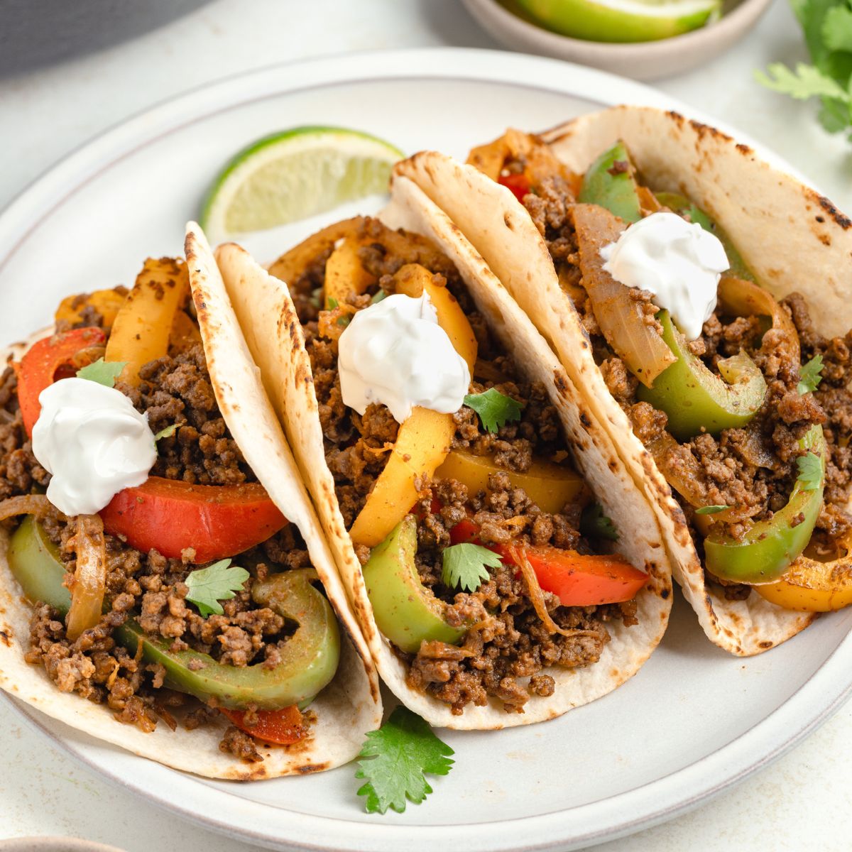 Three flour tortillas filled with seasoned ground beef fajitas.