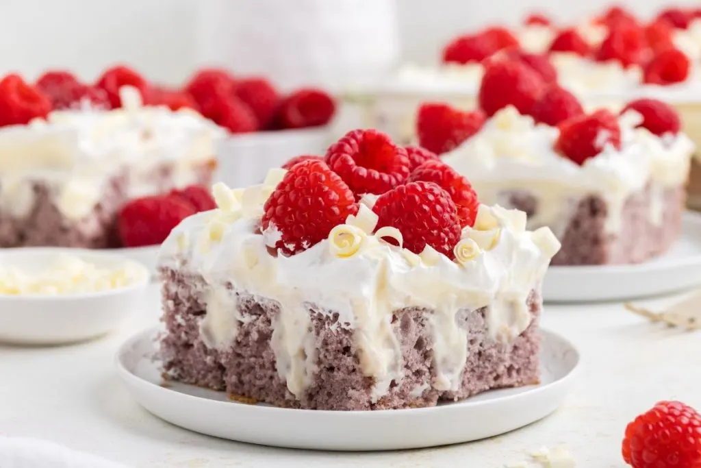 Easy raspberry poke cake with white chocolate pudding on a plate.