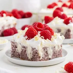 White chocolate raspberry poke cake with fresh raspberries.