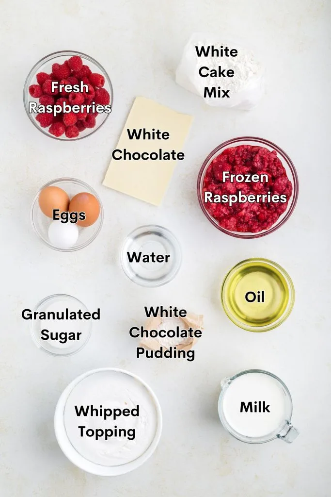 Ingredients such as white cake mix, fresh and frozen raspberries, white chocolate pudding and more displayed on the counter.