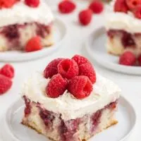 Slice of coconut raspberry poke cake with raspberry preserves.