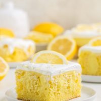 Slice of lemon poke cake with lemon pudding filling and whipped topping.