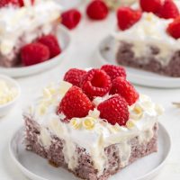 Slice of raspberry poke cake with white chocolate pudding filling.