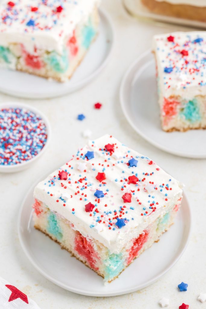 4th of July poke cake with white chocolate pudding frosting and sprinkles.