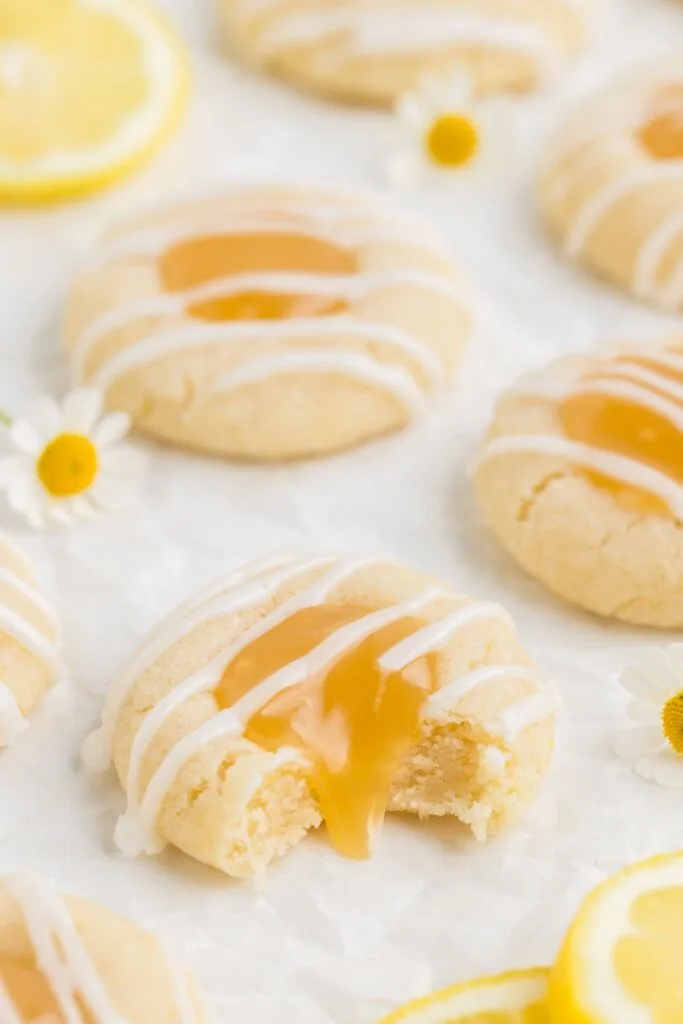 Lemon curd thumbprint cookies with bite missing.