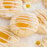 Lemon curd thumbprint cookies with lemon glaze in a pile.