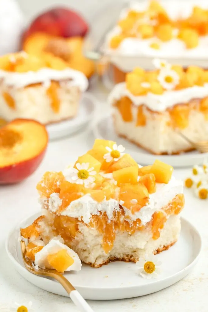 Peach poke cake with bite missing from a fork.