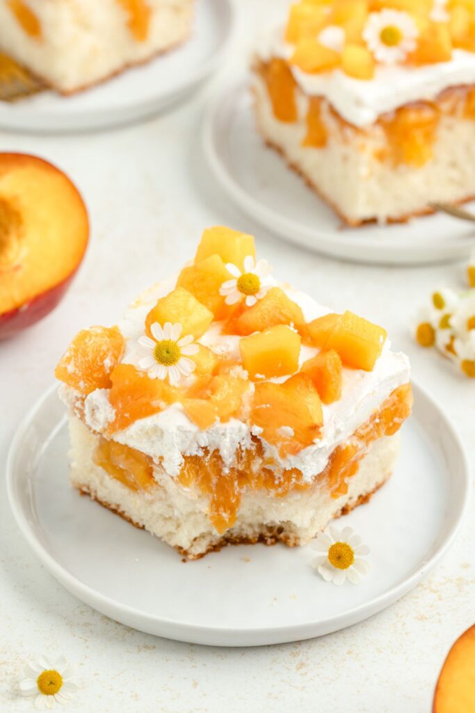 Peach poke cake with forkful missing.