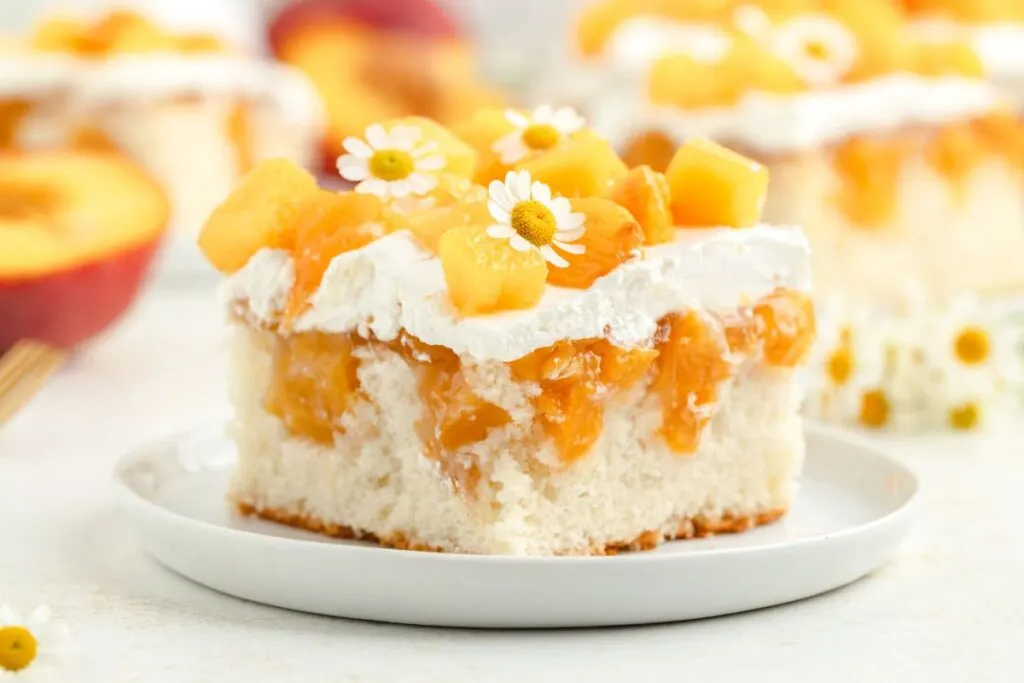 Peach poke cake with pie filling and fresh peaches. 