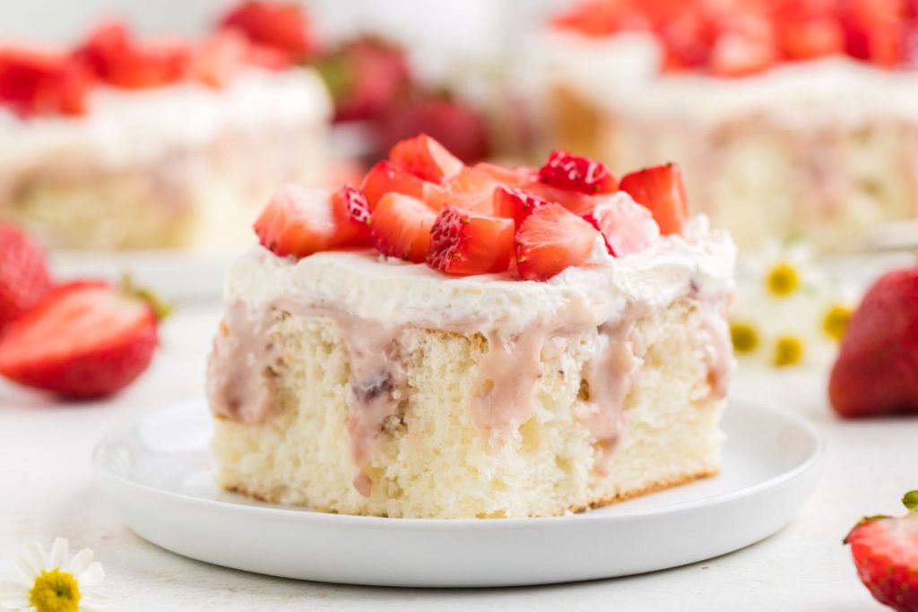 White cake with strawberry cheesecake filling and topped with fresh strawberries.