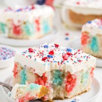 Slice of 4th of July poke cake with forkful missing.