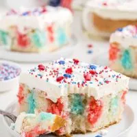 Slice of 4th of July poke cake with forkful missing.
