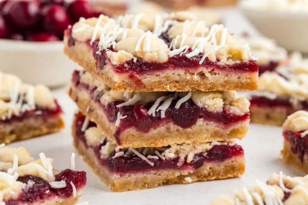 Stack of white chocolate cranberry crumble cookie bars.