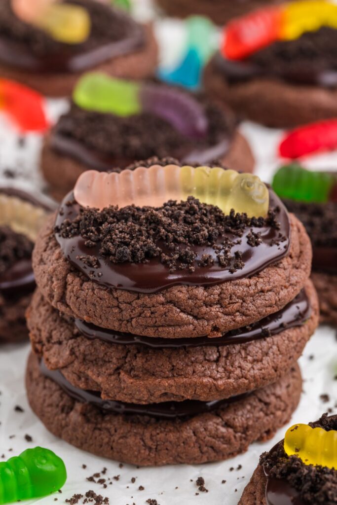 Three dirt and worm cake mix cookies in a stack.